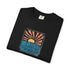 A folded black t-shirt with a colorful graphic print of a sunset over wavy blue water, featuring the text 'GOOD TIMES FROM SUNSET TO SUNSET' repeated around the design.