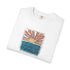 A folded white crewneck t-shirt featuring a colorful graphic print of a rising orange sun over blue wavy water, with the text 'GOOD TIMES FROMSUMBER TO SUNSET' printed around the design.