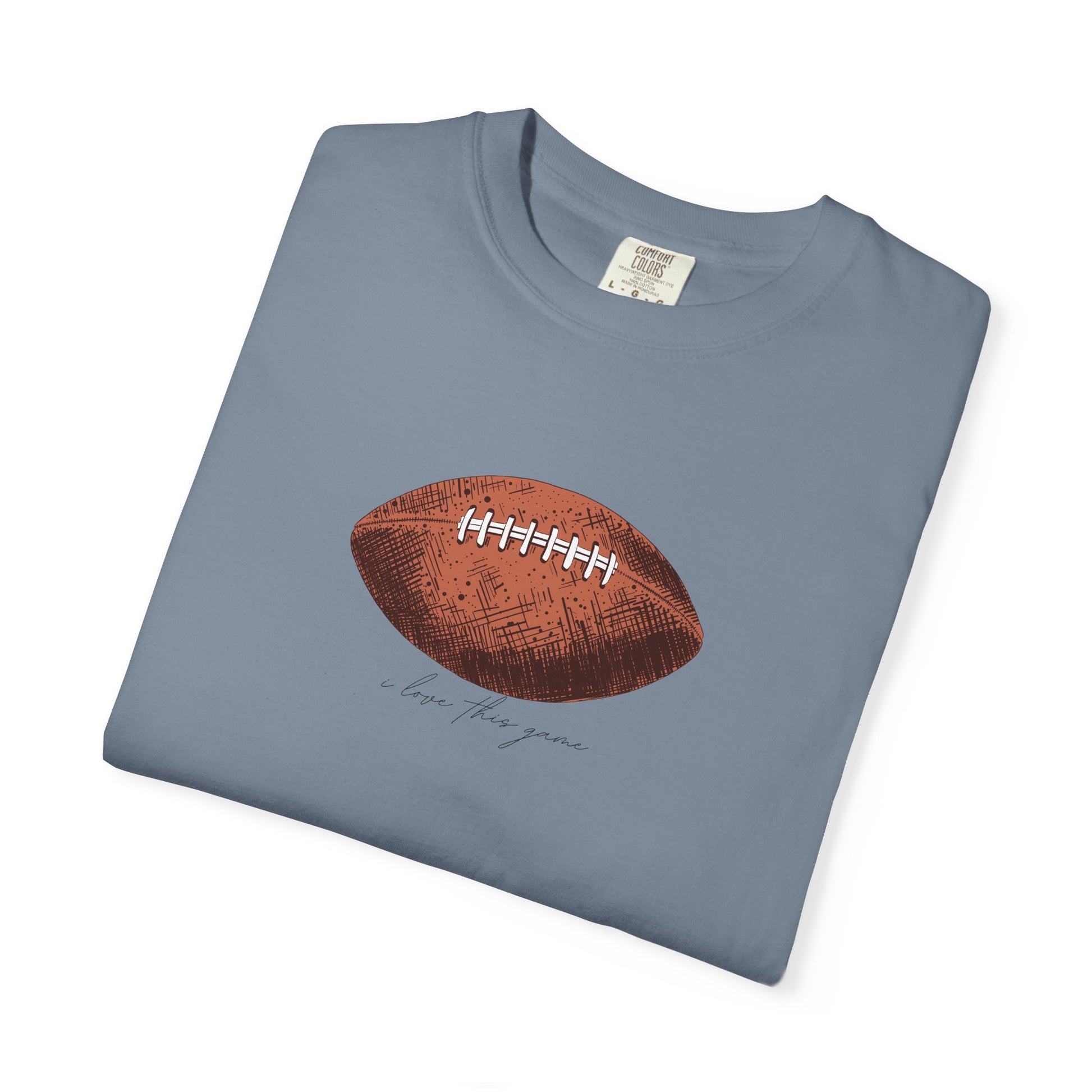 Folded blue t-shirt with a brown football graphic on a white background