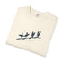 An off-white folded crewneck t-shirt with a dark blue graphic of four surfers on a beach and the text 'Hawaii Surfing' printed underneath.