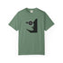 A sage green short-sleeve crewneck t-shirt featuring a black graphic of a woman's profile with a pentagram symbol in her eye, displayed on a clean white background.