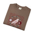 A brown folded t-shirt with a red and white occult-style graphic featuring a bird, moon, sun, and magical symbols.
