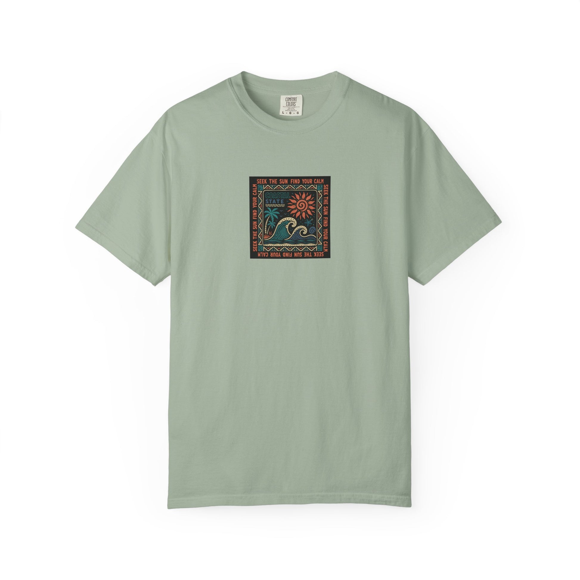 A sage green short-sleeve crewneck t-shirt with a square graphic print on the chest depicting a stylized blue wave and orange sun over a patterned border, shown on a plain white background.
