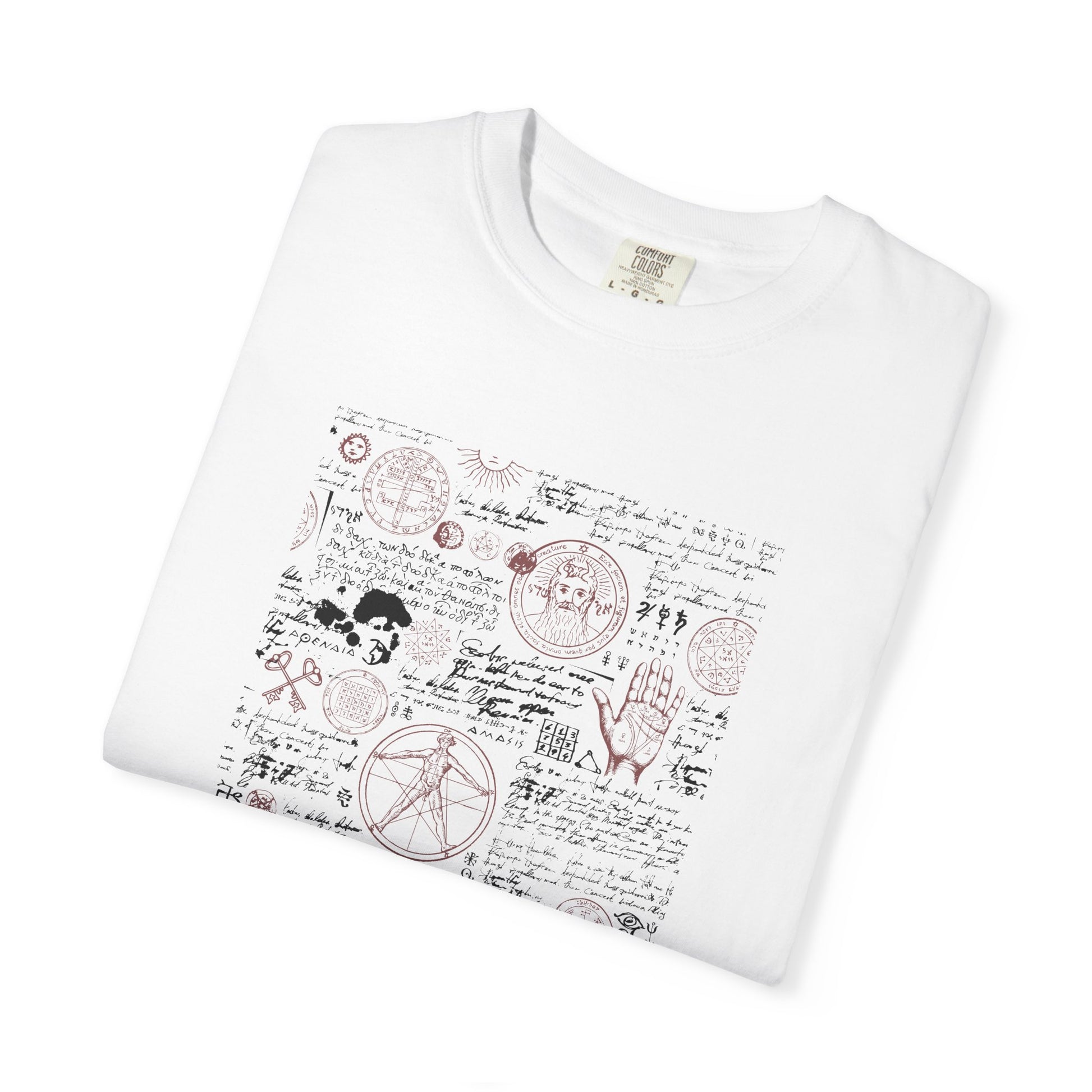 A folded white crewneck t-shirt featuring a vintage-style occult graphic print with hand-drawn pentagrams, a hand, a snake, and cursive script in muted red and black.