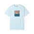 A light blue short-sleeve crewneck t-shirt featuring a central graphic of a sunset over wavy blue-green water, with the text 'I DON'T WANNA BE YOURS' printed around the design.
