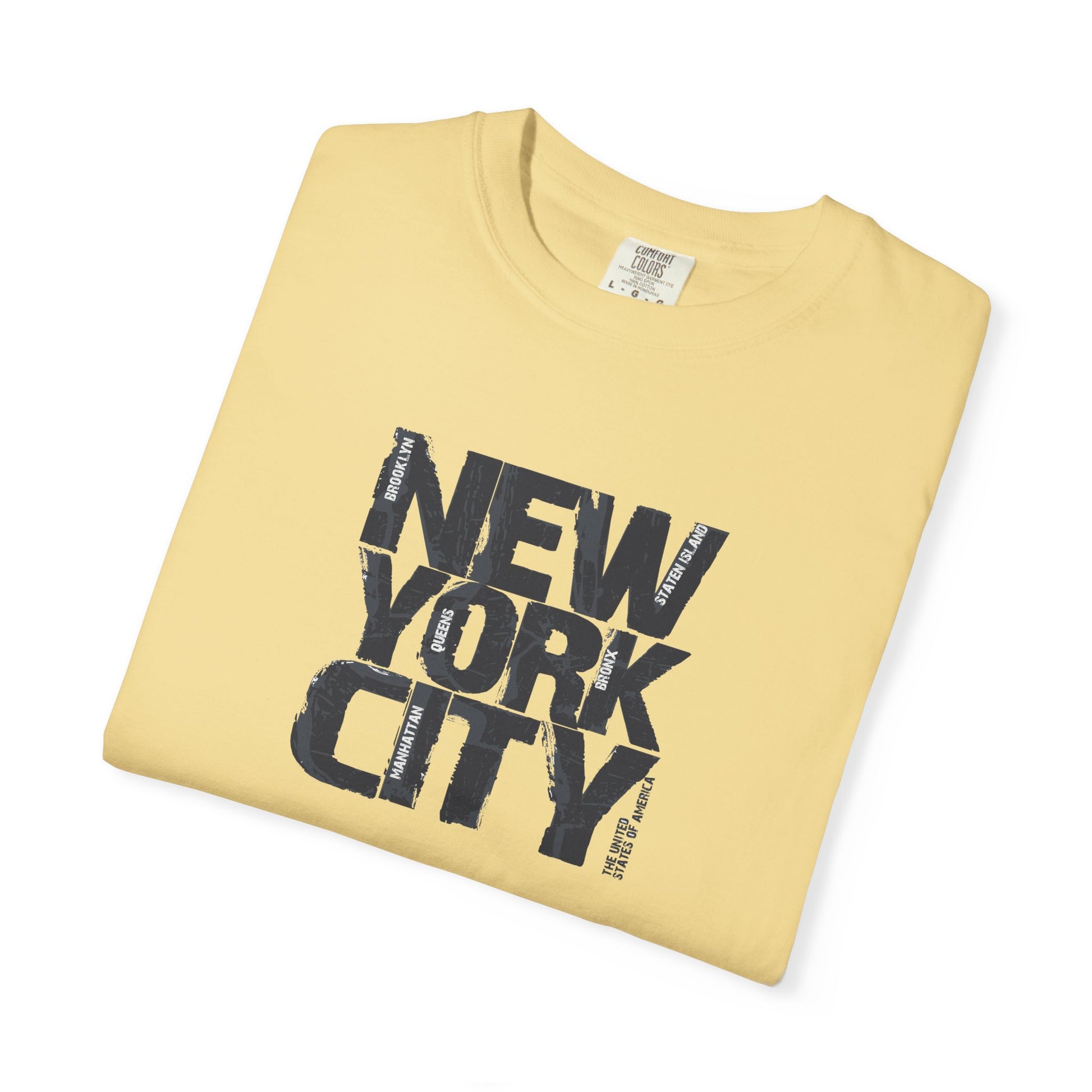 Folded yellow t-shirt with 'New York City' text on a white background