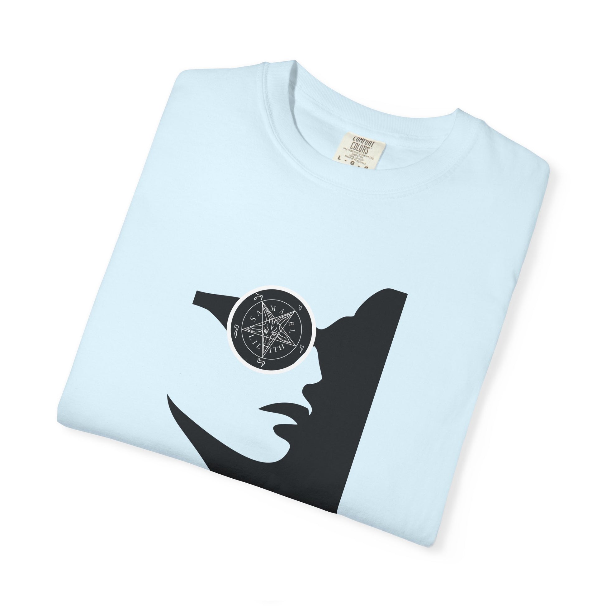 A folded light blue crewneck t-shirt with a black graphic print of a woman's face wearing a circular eyepatch with a pentagram design, shown on a white background.
