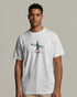 Man wearing a white t-shirt with a graphic design on a plain background